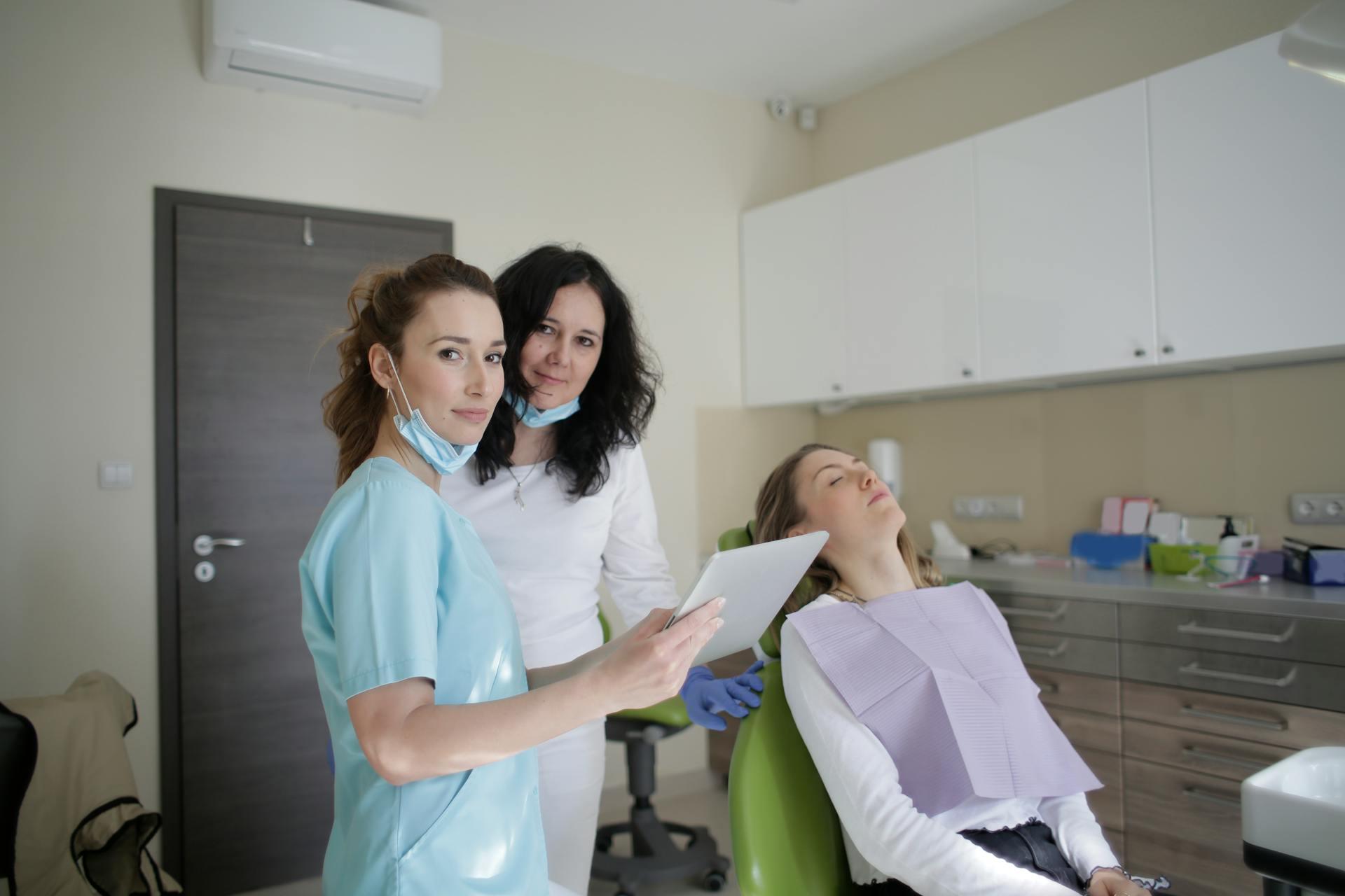 Medical staff with tablet and lying patient in dental clinic, photo by Andrea Piacquadio